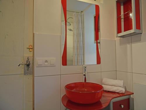 La salle de bains est pourvue d'un lavabo rouge et d'un miroir. dans l'établissement Villa in Artigat near Cathar Castles, cleaning included, à Artigat