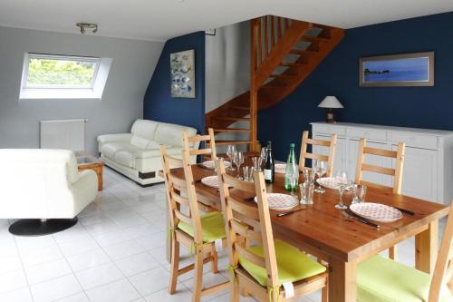 une salle à manger avec une table et des chaises en bois dans l'établissement Holiday Home in Paimpol near Beach, cleaning included, à Paimpol