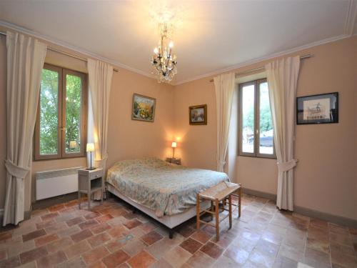 - une chambre avec un lit, 2 fenêtres et un lustre dans l'établissement Holiday Home in Fournès with Private Pool, cleaning included, à Fournès