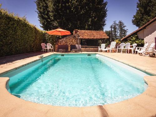 une piscine avec des chaises et un parasol dans l'établissement Cottage in Vézac with Pool and Barbecue, cleaning included, à Vézac