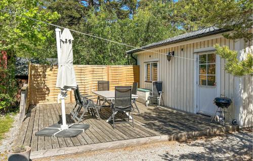 a deck with a table and chairs and an umbrella at Villa Skogshem in Visby