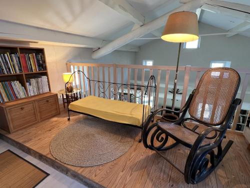 Cette chambre comprend un lit, une chaise et une lampe. dans l'établissement Villa in Banne with Pool and Nature Trails, cleaning included, à Banne