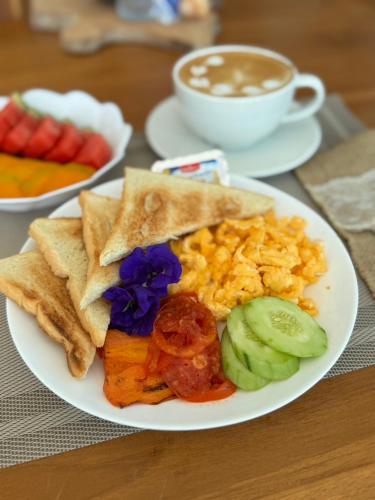 a plate of breakfast food with a cup of coffee at Reboot Retreat Beach Resort, Restaurant, and Coffee Shop in Ban Talat Bang San