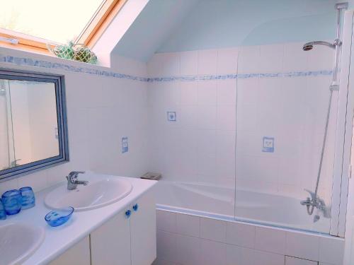 une salle de bain blanche avec un lavabo et une douche dans l'établissement Stone House in Brittany near the Sea, cleaning included, à Lannilis