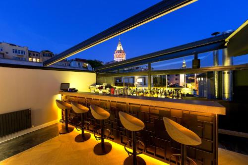 a bar on the roof of a building with stools at Walton Hotels Galata in Istanbul