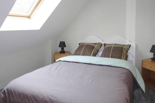 une chambre avec un lit blanc avec une lucarne dans l'établissement Holiday Home in Erquy near Sandy Beaches, cleaning included, à Erquy