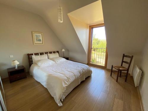 une chambre avec un grand lit et une fenêtre dans l'établissement Stone House in Brittany near Scenic Bay, cleaning included, à Planguenoual