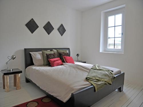 une chambre avec un grand lit avec des oreillers rouges dans l'établissement Pool Villa in Artigat Valley, cleaning included, à Artigat