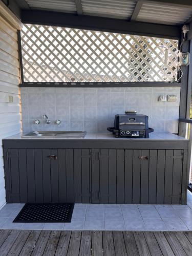 a kitchen with a counter with a sink and a microwave at Diamond Beach Holiday Park in Diamond Beach