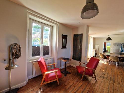 un salon avec des chaises rouges et une table dans l'établissement Holiday Home Locquirec by Sandy Beach, cleaning included, à Locquirec