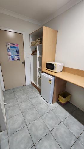 a small kitchen with a counter and a microwave at T's Resort & Motel in Port Macquarie