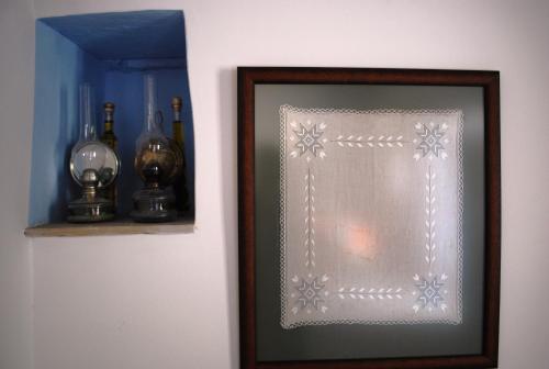 a picture in a frame next to a shelf with bottles at To Archontiko tis Anastasias in Athienou
