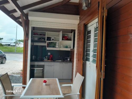 Una cocina al aire libre con mesa y sillas. en EDEN EVe, en Sainte-Anne