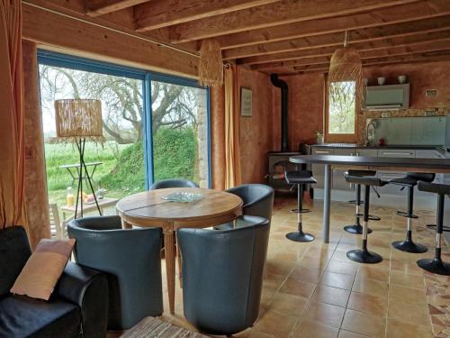 un salon avec une table et des chaises et une fenêtre dans l'établissement Stone House near Rosa Granite Coast, cleaning included, à Bas Kerhain