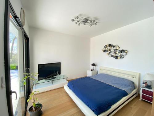 une chambre avec un lit et une télévision à écran plat dans l'établissement House in Margaux with Saltwater Pool & Vineyards, cleaning included, à Margaux