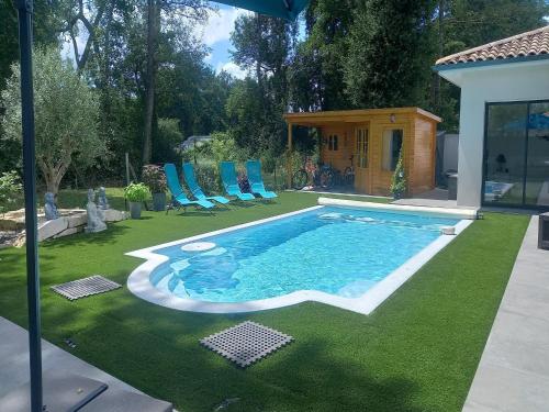 une piscine sur herbe avec des chaises et une maison dans l'établissement House in Margaux with Saltwater Pool & Vineyards, cleaning included, à Margaux