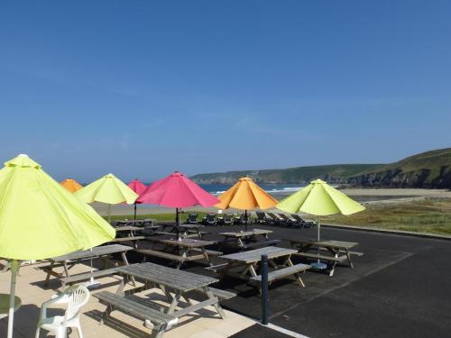 un groupe de tables et de chaises avec parasols dans l'établissement Studio in Audierne near Finistère Beach, cleaning included, à Audierne