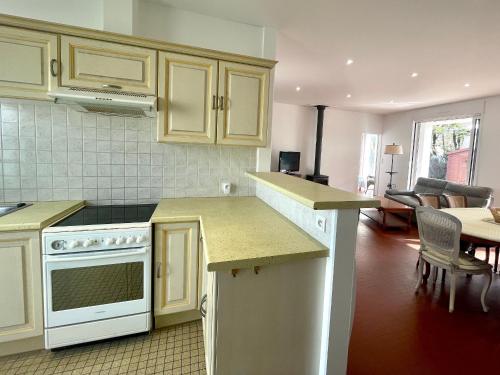 Il comprend un salon et une cuisine équipée d'appareils électroménagers blancs. dans l'établissement Maison familiale 3 chambres avec jardin, terrasse en bois, proche de la mer et des sentiers. - FR-1-231-313, à Bretignolles-sur-Mer