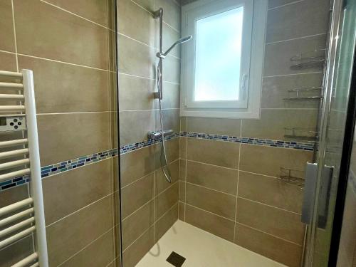 une salle de bain avec une douche avec une porte vitrée dans l'établissement Maison familiale 3 chambres avec jardin, terrasse en bois, proche de la mer et des sentiers. - FR-1-231-313, à Bretignolles-sur-Mer