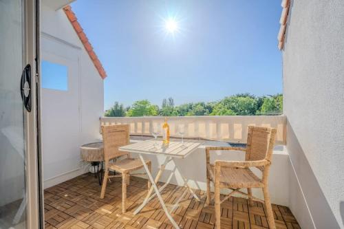 un patio avec une table et des chaises sur un balcon dans l'établissement Apartment of the Flying Bridges, à La Rochelle
