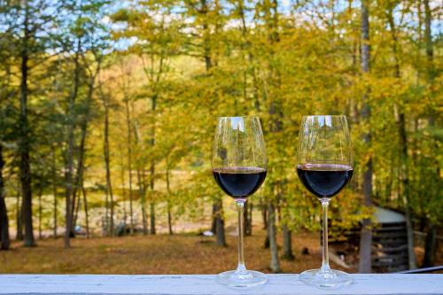 two glasses of red wine sitting on a table at Spacious Catskills Serenity nearby Delaware River Gap w Game Rm Pet Friendly and Fenced Yard in Glen Spey