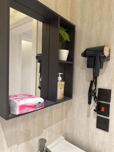 a bathroom with a mirror and a sink at سُكنا الوردة الحمراء in Al Khobar
