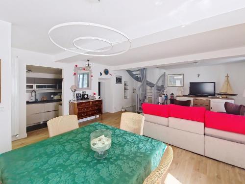 un salon avec un canapé rouge et une table dans l'établissement Maison rénovée proche plage et commerces, 3 chambres, 3 salles d'eau, confort moderne. - FR-1-331-86, à Les Sables-dʼOlonne