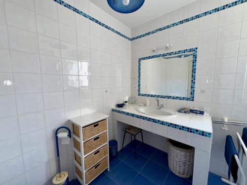 une salle de bain blanche avec un lavabo et un miroir dans l'établissement Maison spacieuse avec jardin, proche forêt et plage, 3 chambres, équipements de loisirs, parking privé - FR-1-323-435, à Saint-Jean-de-Monts