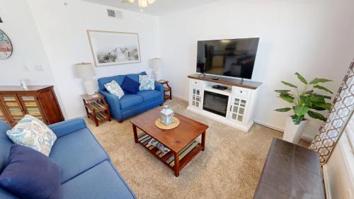 a living room with a blue couch and a tv at Islander Beach Resort 6007 in Fort Walton Beach
