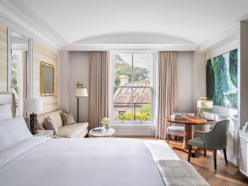 a hotel room with a bed and a desk and a window at The Langham Sydney in Sydney