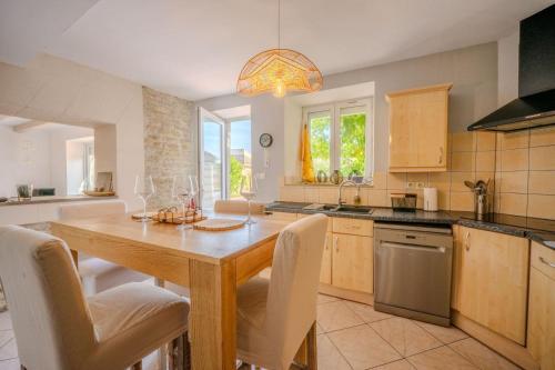 une grande cuisine avec une table et des chaises en bois dans l'établissement The Villa of the Whispers of the South-West, à Villedoux