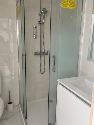 une douche avec une porte vitrée dans une salle de bain dans l'établissement Royal appart city 2, à Calais