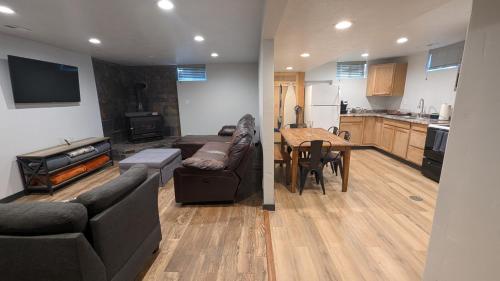 a living room with a couch and a table and a kitchen at Canyon Coze - Ski, Board, Sled, Bike, Hike in Ogden