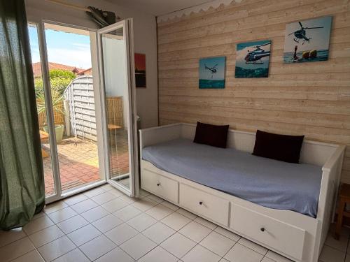 une chambre avec un lit et une porte coulissante en verre dans l'établissement Appartement à deux pas de la mer, Biscarrosse Plage - 4 pers. - Terrasse et Parking inclus - FR-1-319-447, à Biscarrosse