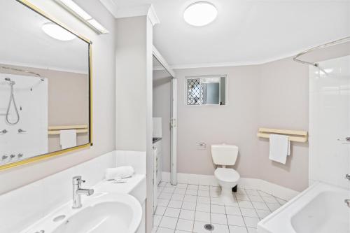 a white bathroom with a sink and a toilet at Citysider Cairns Holiday Apartments in Cairns