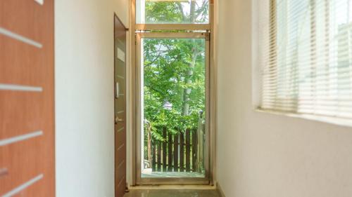 a mirror in a room with a door and a window at Gangneng badapunggeong Pension in Gangneung