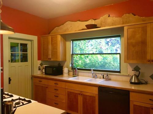 a kitchen with a sink and a window at Charming 1914 Craftsman Home in Eugene