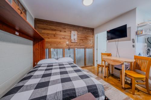 une chambre avec un lit, une table et une télévision dans l'établissement Hilltop Cottage, à Panguitch
