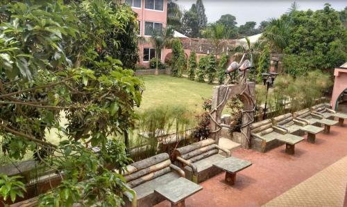 a row of benches in a garden with a park at Imperial Golf View Hotel in Entebbe
