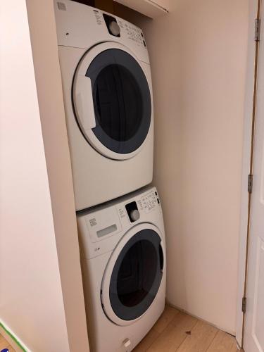 two microwaves are stacked on top of a washing machine at Peaceful 2-bedroom, 1-bath daylight suite with private entrance in West Kelowna