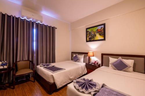 Postel nebo postele na pokoji v ubytování Baly Hotel Hue