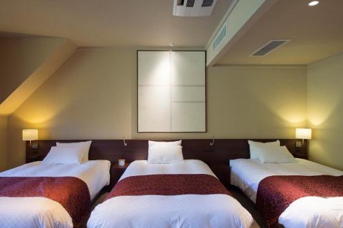 three beds in a room with a large mirror at Izumigo Takayama Dog Paradise Hotel in Takayama