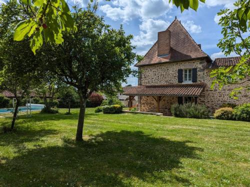 an old stone house with a tree in the yard at Gîte spacieux avec piscine privative, grand jardin et équipements bébé en Charente Limousine - FR-1-653-67 in Esse