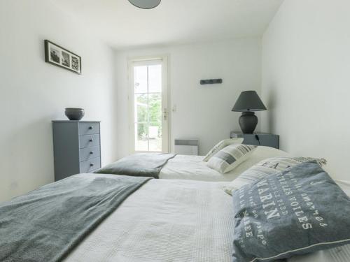 - 2 lits dans une chambre blanche avec fenêtre dans l'établissement Maison de plain pied avec jardin clos pour 6 personnes - FR-1-835-26, à Sainte-Marie de Ré