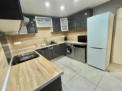 La cuisine est équipée d'un réfrigérateur blanc et d'un lave-vaisselle. dans l'établissement Magnifique appartement P3 climatisé avec parking privé - FR-1-716-90, à La Grande Motte