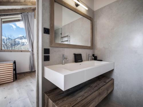 La salle de bains est pourvue d'un grand lavabo blanc et d'un miroir. dans l'établissement Chalet moderne à Villarabout - 12 pers, 260m², sauna, salle de cinéma - FR-1-570-68, à Béranger