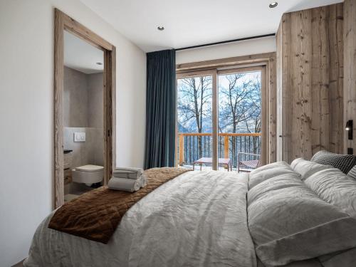 une chambre avec un grand lit et une grande fenêtre dans l'établissement Chalet moderne à Villarabout - 12 pers, 260m², sauna, salle de cinéma - FR-1-570-68, à Béranger