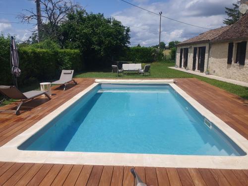 une grande piscine sur une terrasse en bois dans l'établissement Gîte Authentique Calme avec Piscine et Jardin Privé - FR-1-616-474, à Sainte-Sabine