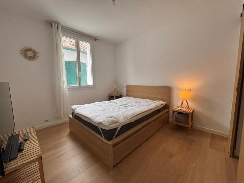 - une chambre avec un lit, une fenêtre et une lampe dans l'établissement Superbe appartement 2 chambres, à deux pas du centre - FR-1-239-1128, à Saint-Jean-de-Luz