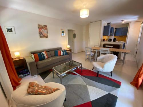 un salon avec un canapé et une table dans l'établissement Appartement T2 verdoyant avec parking privatif - FR-1-374-238, à Arcachon